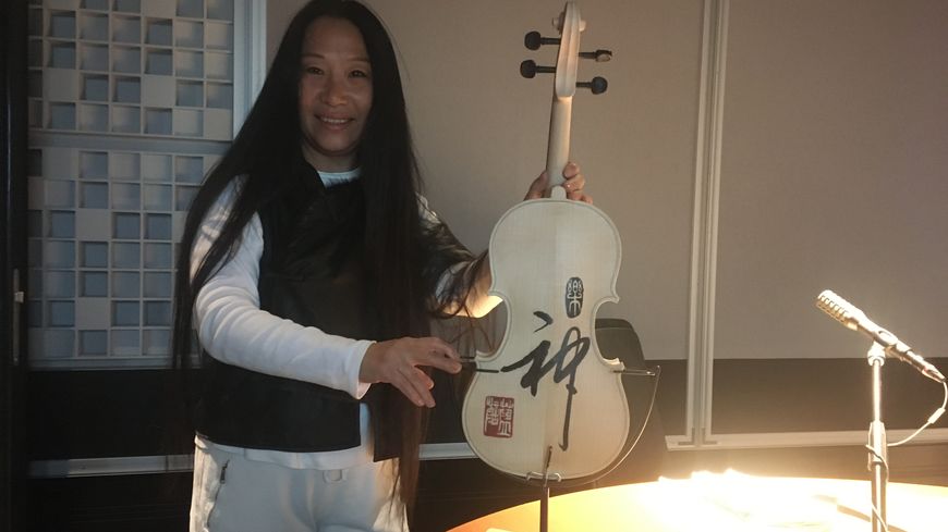 Li Chevalier avec l'un des violons de l'installation "Symphonie visuelle"