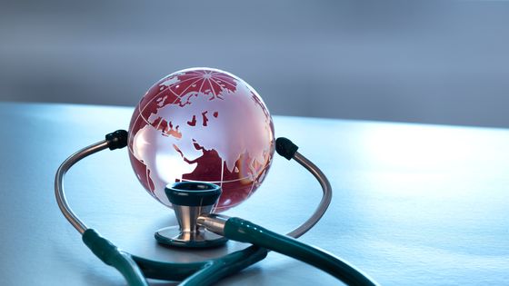 La santé mondiale représentée par un globe en verre et un stéthoscope - Westend61
