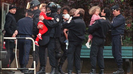 Des policiers évacuent les derniers enfants otages de la maternelle Commandant Charcot, le 15 mai 1993 à Neuilly-sur-Seine. ©AFP - Pierre Boussel