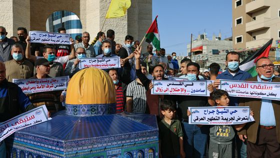Des Gazaouis du camp de Rafah manifestent autour d'une miniature de la mosquée Al Aqsa, lieu saint au coeur des tensions, lors d'une manifestation en soutien aux Palestiniens de Jérusalem ©AFP - SAID KHATIB