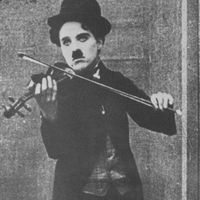Chaplin interprétant un musicien de rue dans Le vagabond (1915)