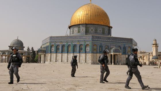 Les forces de sécurité israéliennes passent devant le Dôme du Rocher alors qu'elles évacuent l’esplanade de la mosquée Aqsa de Jérusalem des manifestants palestiniens, le 10 mai 2021. ©AFP - AHMAD GHARABLI