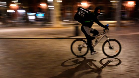 Un cycliste d'Uber Eats en livraison pendant le couvre-feu, place Saint-Pierre à Toulouse (16/01/21) - Georges Gobet / AFP