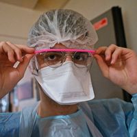 Un membre du personnel médical se préparant avant de prendre en charge un patient Covid-19 à l'unité de soins intensifs de l'hôpital de Tours, le 2 avril 2021.