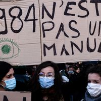 Une manifestante tient une pancarte indiquant "1984 n'est pas un manuel" sur la place de la République à Paris, lors d'une manifestation contre la loi sur la "sécurité globale".