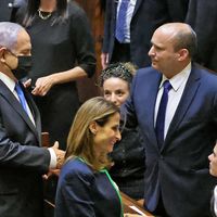 Benjamin Netanyahu serre la main de son successeur, le nouveau Premier ministre Naftali Bennett, après une session extraordinaire pour voter sur un nouveau gouvernement