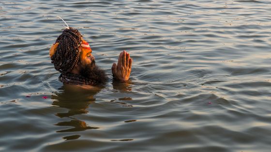 Sadhu, homme saint, prenant un bain et priant juste avant le coucher du soleil. ©Getty