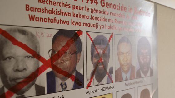 Les visages, barrés de rouge, des génocidaires rwandais traqués à l'étranger ©AFP - Simon Wolfhart / AFP