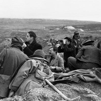 L'écrivain Ernest Hemingway parmi d'autres reporters de guerre et des soldats des troupes républicaines sur une ligne de front de la guerre d'Espagne, en 1937