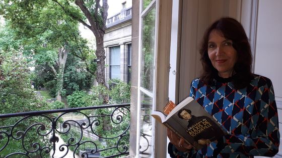 Laurence Bertrand Dorléac dans son bureau de présidente de la FNSP, un abécédaire de Tocqueville à la main et la vue sur l'arbre de Judée du jardin de Sciences po. ©Radio France - Sophie Delpont