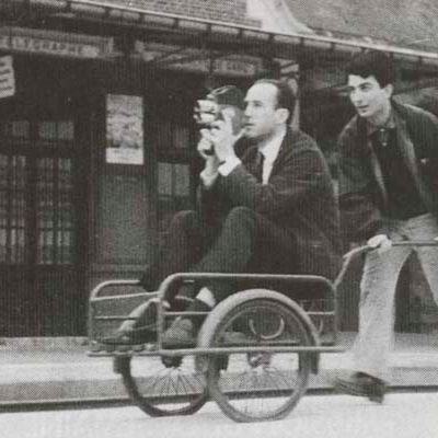 Tournage de "La Gare" (1966). Nestor Almendros sur un chariot à bagages pour un travelling sur les quais de la gare de Beauvais