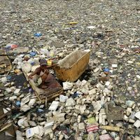 Teresita Gapayao, charognarde, se promène dans les ordures à l'aide d'un radeau de fortune en polystyrène sur l'Estero de Vitas à Tondo, Manille (Philippines)