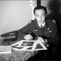 Portrait d'archives daté de novembre 1945 de l'écrivain français Romain Gary en uniforme militaire signant des autographes sur ses photos