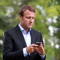 Emmanuel Macron consultant son portable. Photo prise en août 2015.