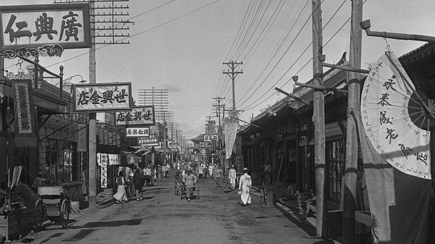 Scène de rue : piétons, rickshaw et devantures à Shanghai en 1930