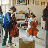 Enfants jouant des instruments à cordes sous l'oeil de leur père