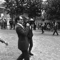 Jean-Luc Godard, caméra au poing, dans la manifestation des étudiants à Paris, le 13 mai 1968