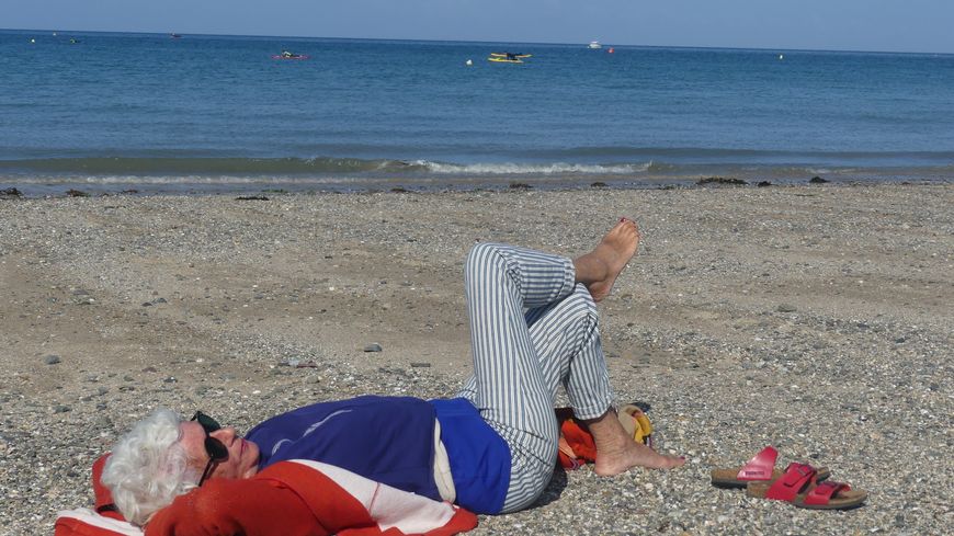 Marie-Christine, tombée sur le concert par hasard, s'allonge sur le sable pour en profiter