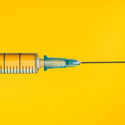 Seringue contenant une solution liquide sur fond jaune