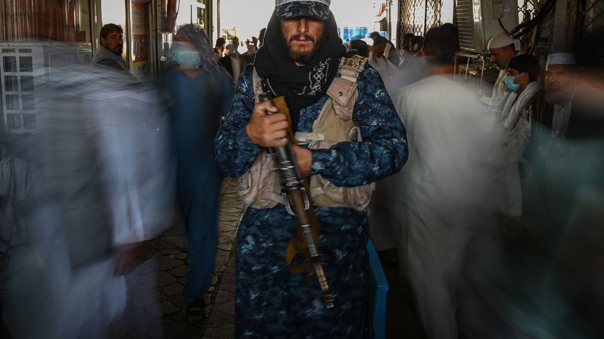 Dans un marché de Kaboul, un taliban pose au milieu des boutiques de change le 7 septembre.