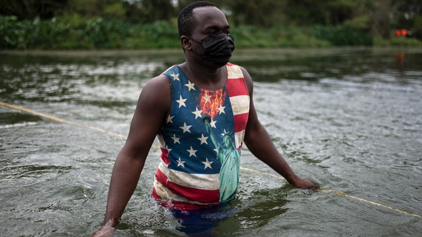 Un Haïtien traverse lui aussi le Rio Grande avec son T-shirt aux couleurs de l'Amérique en quête de nourriture