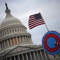 Le 6 janvier 2021, des partisans du président américain Donald Trump font flotter un drapeau américain avec le symbole du groupe QAnon alors qu’ils se rassemblent devant le Capitole à Washington.