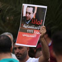 Un soutien du Hezbollah brandit une pancarte demandant le limogeage du juge Tarek Bitar, le 14 octobre 2021