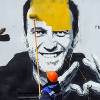 Un emplyé municipal de Saint Petersbourg recouvre de peinture une fresque murale à l’effigie de l’opposant emprisonné Alexei Navalny, en avril 2021.