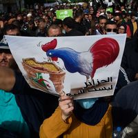 Algériens clamant des slogans anti-français lors d’une manifestation antigouvernementale à Alger le 9 avril 2021. Affiche : « l’Algérie n’est pas à vendre ».