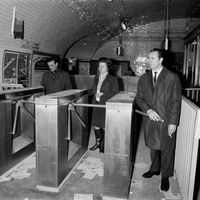 Des voyageurs empruntent la poinçonneuse automatique mise en place à titre expérimental par la RATP à la station Porte de Vanves, le 15 février 1969 à Paris.