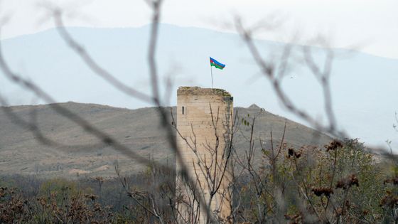 Le drapeau azéri flotte au vent sur une tour à la sortie de Fuzuli, ville occupée jusqu'en 2020 par l'Arménie. ©AFP - TOFIK BABAYEV / AFP
