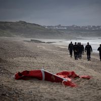 Police française sur une plage du nord de la France où gît un gilet de sauvetage utilisé par des migrants tentant de rejoindre l’Angleterre le 16 octobre 2021.