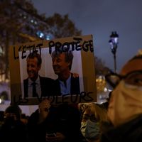 Manifestation contre les violences faites aux femmes à Paris le 25 novembre 2021. Une manifestante tient une pancarte représentant Nicolas Hulot.