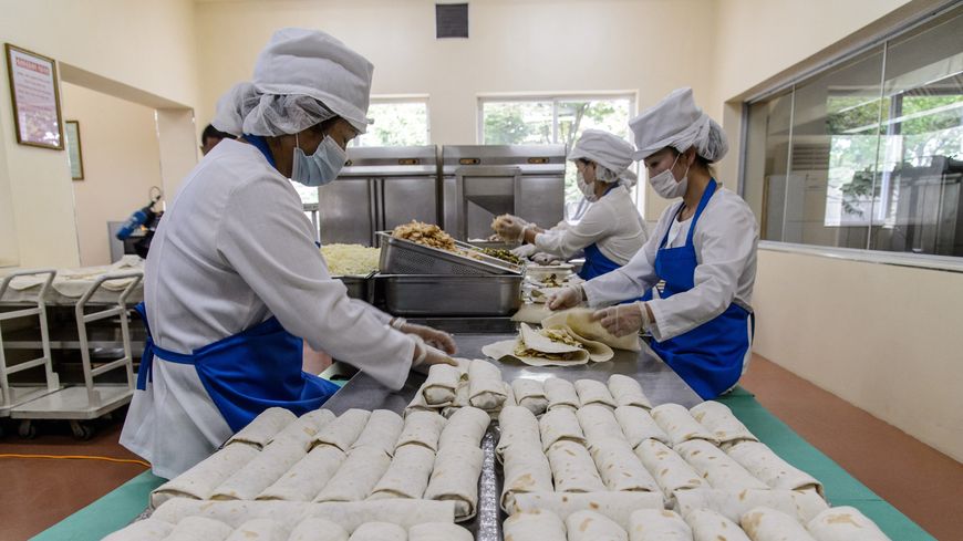 Des employées garnissent des galettes de viande à la Kumsong Foodstuff Factory à Pyongyang le 24 septembre 2021.