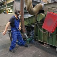 Ouvrier effectant le débourrage d'une machine dans l'usine du Relais Métisse (structure d'insertion d'économie circulaire et solidaire)