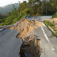 Une route coupée en deux après un typhon et des pluies torrentielles à Okinawa