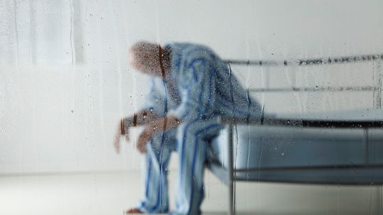 Homme derrière une vitre de pluie ©Getty - Vandervelden