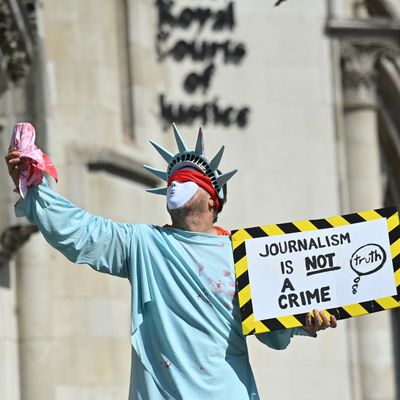 Un manifestant déguisé en Statue de la Liberté tient une pancarte en soutien à Julian Assange devant la Cour Royale de Justice à Londres, le 11 août 2021.