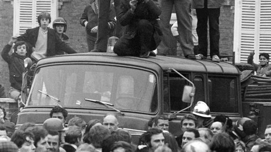 Le maire d'Auby prononce un discours sur le toit d'un fourgon entouré de militants de la GCT, manifestants et forces de police, lors d'une manifestation de 1980 ©AFP - Jean Meunier