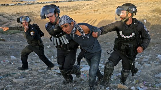 Forces de sécurité israéliennes arrêtant un jeune manifestant bédouin à Sa’we al-Atrash le 13 janv. ©AFP - Menahem Kahana