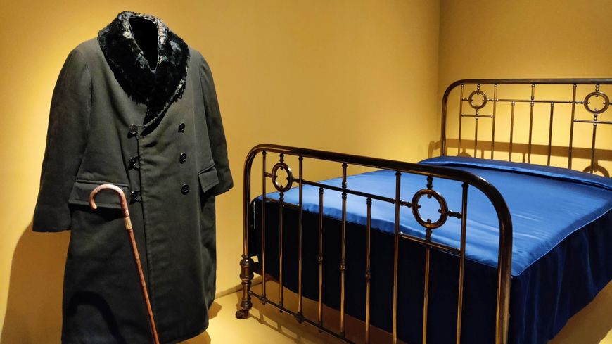 Au musée Carnavalet, canne et manteau de Proust exposés à côté du lit qui l'a vu écrire et mourir.