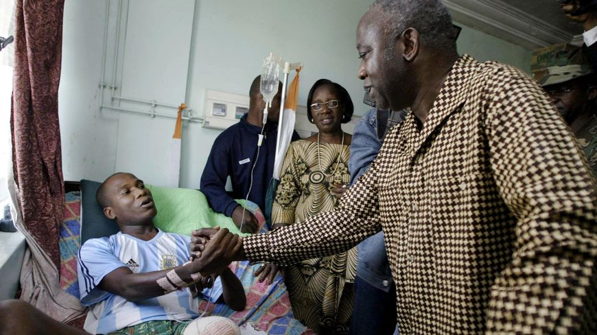 Laurent Gbagbo alors Président de la Côte d’Ivoire à l’hôpital d’Abidjan le 29 décembre 2004, saluant un homme blessé lors des émeutes anti-françaises.