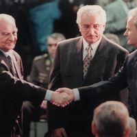 Le président bosniaque serre la main du président serbe, devant le président croate au début des pourparlers de paix Dayton.