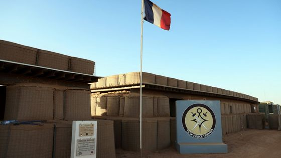 Drapeau français flottant au-dessus du logo de la Force Takuba le 7 décembre 2021 à la base de Menaka dans le Sahel. ©AFP - Thomas COEX