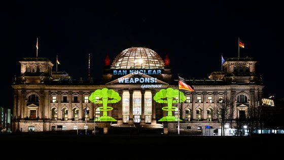 Des activités de Greenpeace projettent sur la façade du Reichstag, le parlement allemand, un message contre le nucléaire militaire le 21 janvier 2022 ©AFP - Tobias Schwarz