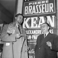 L'acteur Pierre Brasseur et l'écrivain et philosophe Jean-Paul Sartre, devant l'affiche de "Kean" au Théâtre Sarah Bernhard, novembre 1953