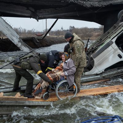 Des soldats ukrainiens évacuent une femme à Irpin dans la banlieue de Kiev ce 7 mars 2022