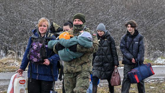 Un soldat polonais porte un enfant et aide une famille de réfugiés après qu'ils ont traversé la frontière polonaise depuis l'Ukraine ©AFP - Louisa GOULIAMAKI