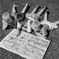 Trois garçons lisant des bandes dessinées dans les années 50.