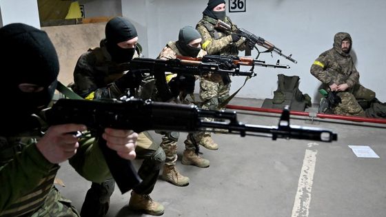 Des combattants des Forces de défense territoriale, dans un garage souterrain de Kiev transformée en base logistique et d'entraînement. ©AFP - SERGEI SUPINSKY